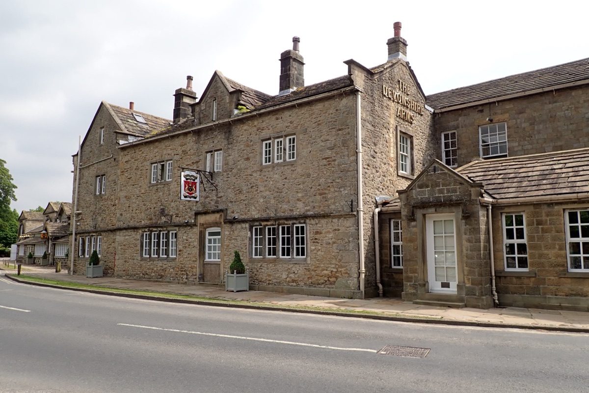 The stone front of the Devonshire Arms Hotel beside the road at Bolton Bridge